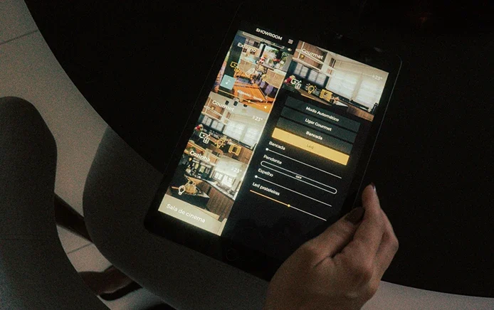 Pessoa controlando os ambientes de uma casa inteligente por aplicativo em um tablet
